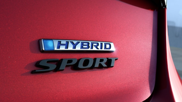 Closeup of “Hybrid” and “Sport” emblems on the trunk door of a red Accord.