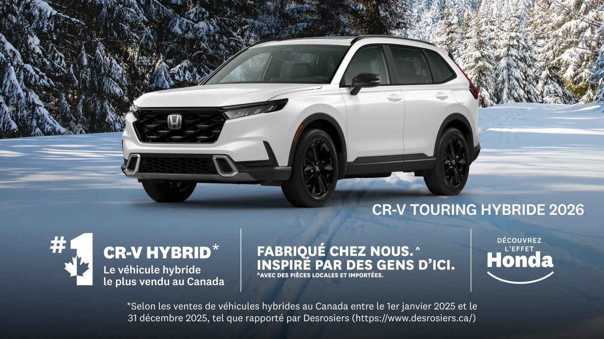 Un Honda CR-V blanc stationné sur une route enneigée, avec des arbres recouverts de neige en arrière-plan.