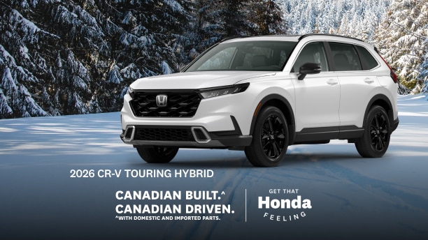 A white Honda CR-V parked on a wintery road with snow covered trees behind.