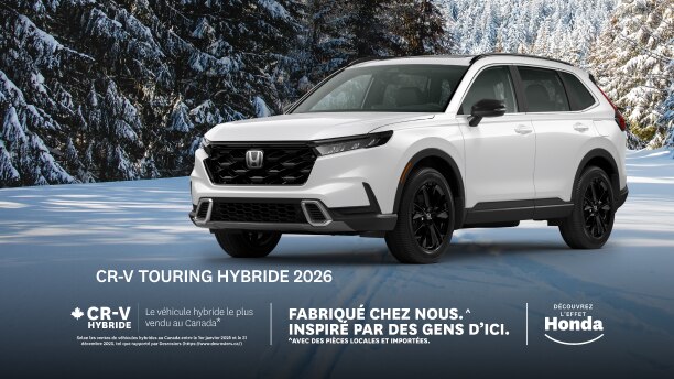 Un Honda CR-V blanc stationné sur une route enneigée, avec des arbres recouverts de neige en arrière-plan.