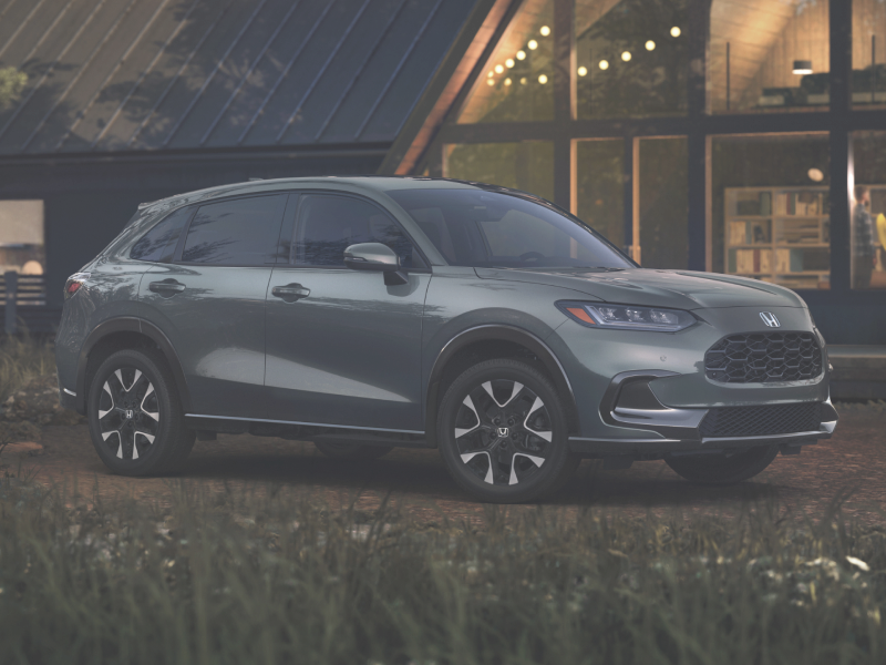 Vue 3/4 avant latérale d’un HR-V gris stationné devant un chalet en A.