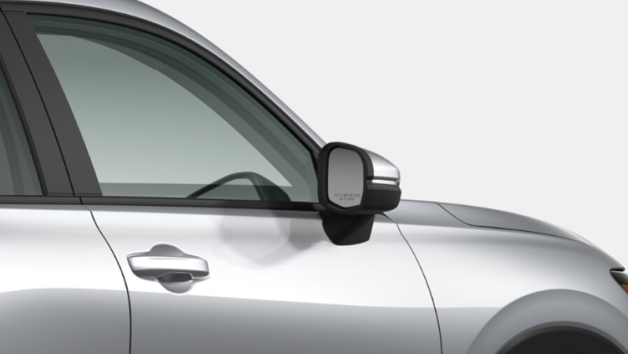 Vue latérale recadrée de la moitié arrière d'une Honda gris sur un fond blanc.