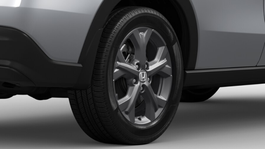 Cropped side-view of the rear half of a red Honda set against a white background.  	Vue latérale recadrée de la moitié arrière d'une Honda rouge sur un fond blanc.