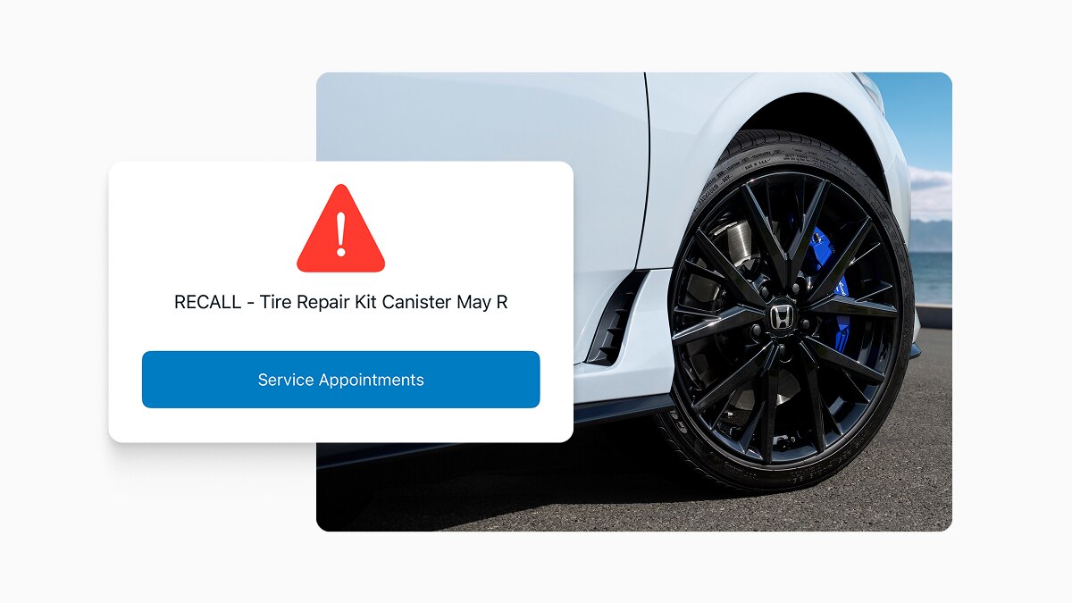 Capture d’écran de l’application HondaLink montrant une notification de rappel, superposée à l’image de la roue d’un véhicule Honda. 