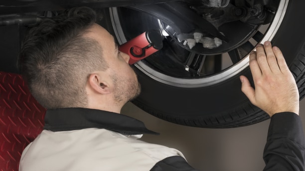 Closeup of Honda Technician inspecting the disc brake on an Honda.