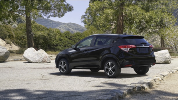 Vue arrière d’un VUS Honda noir stationné dans une forêt.