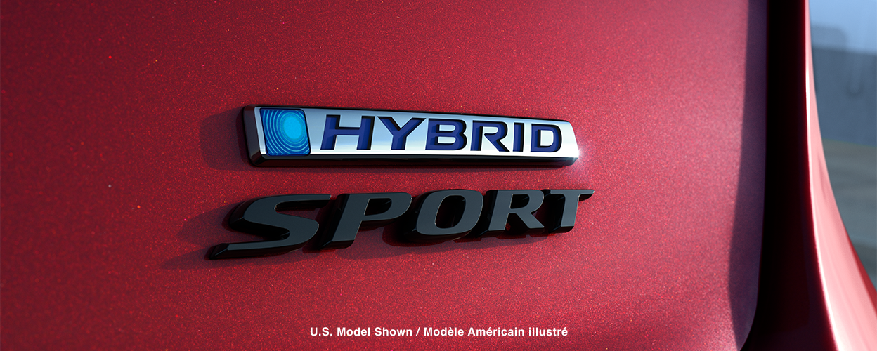 Gros plan des emblèmes « Hybrid » et « Sport » sur le coffre d’une Accord rouge.