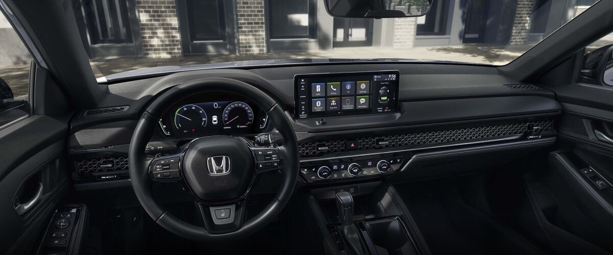 Vue panoramique large du volant et du tableau de bord. Un immeuble à condos tendance vu à travers le pare-brise.