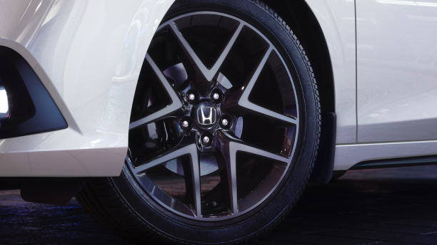 Closeup of wheel on a white Hatchback. 