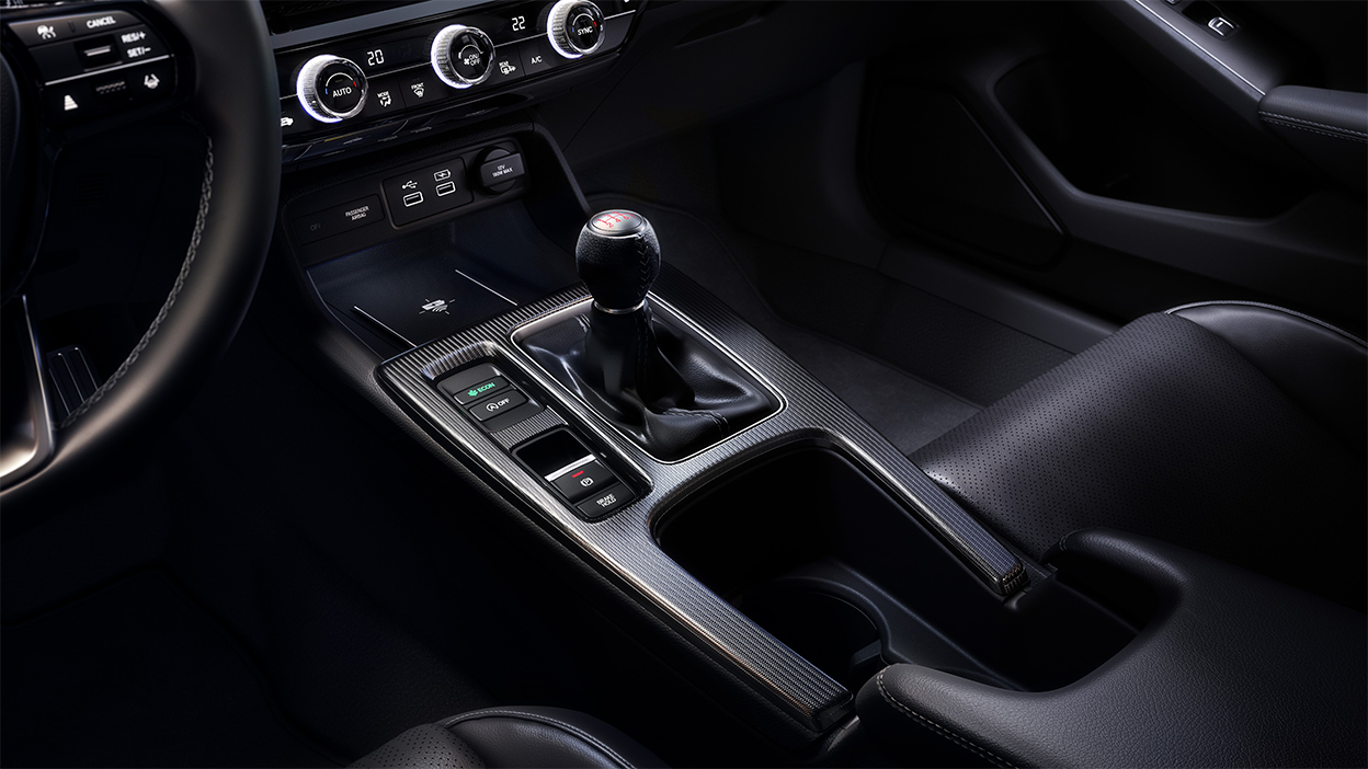 Closeup of gear shifter and cupholder console.