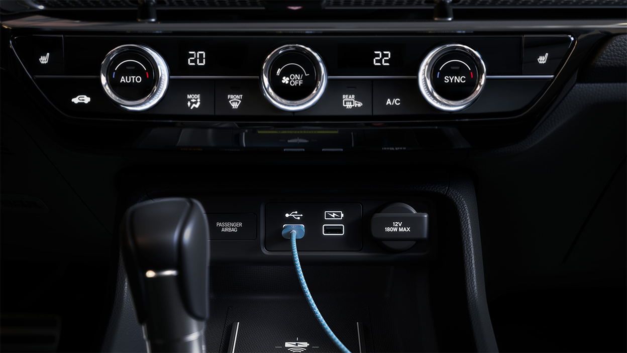 Closeup of climate control dials and USB ports in centre console.