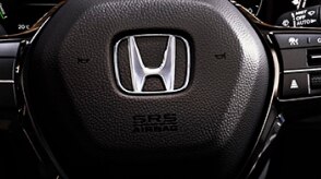 Gros plan du volant avec logo Honda. 