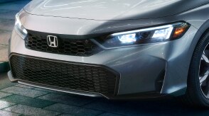 Plan de trois quarts de l’avant d’une Civic à hayon grise.