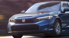 3/4 medium closeup front view of blue Civic Sedan driving.