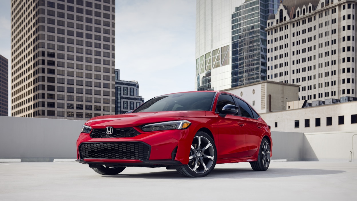 3/4 front view of red Civic Sedan parked in an empty rooftop parkade.