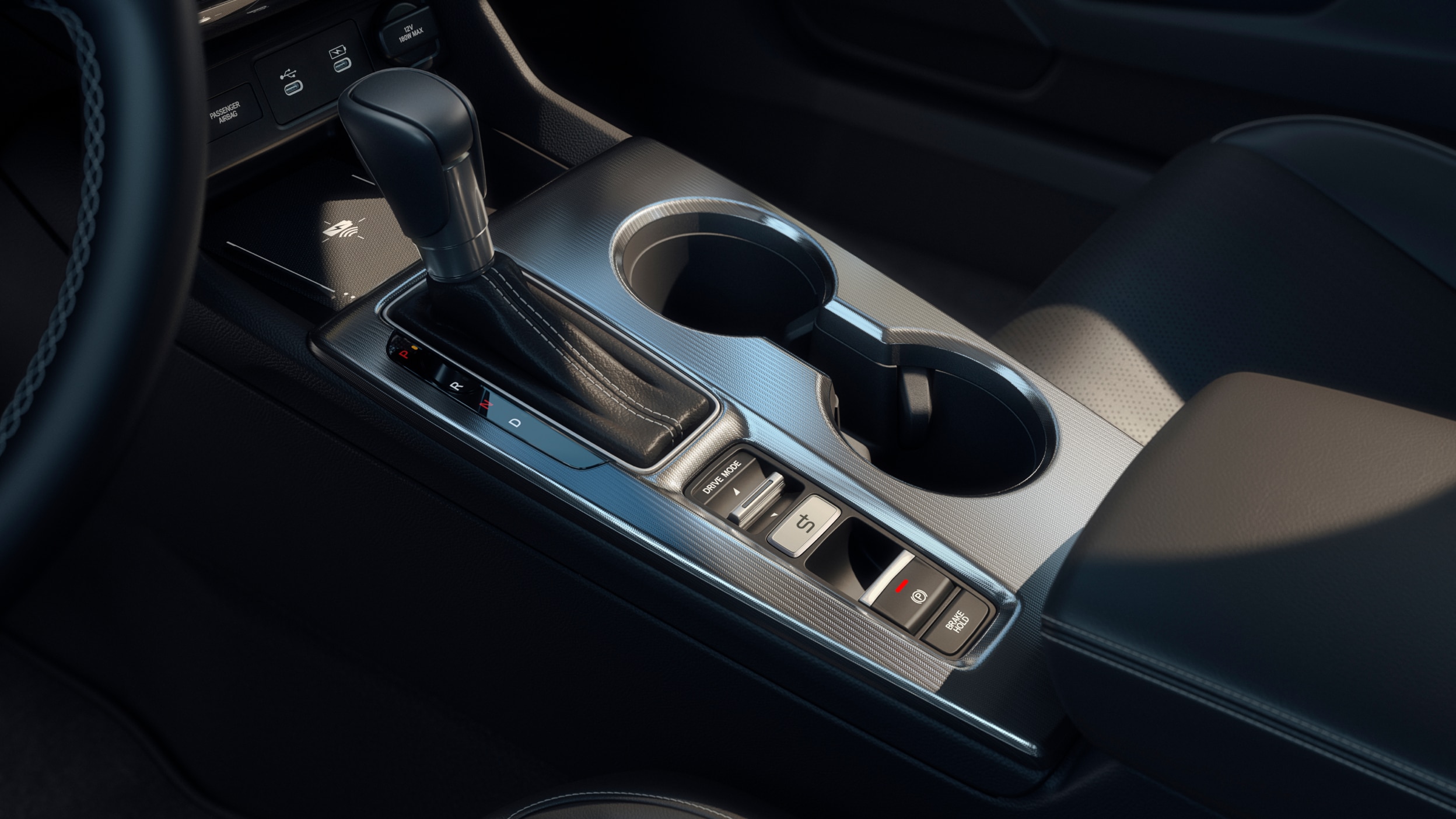 Closeup of gear shift and cup holders in centre console.