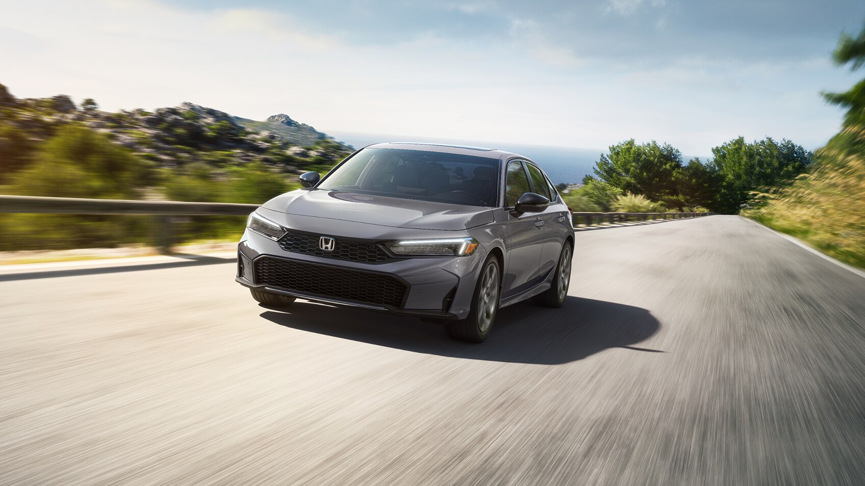 Front view of grey Civic Sedan driving outdoors