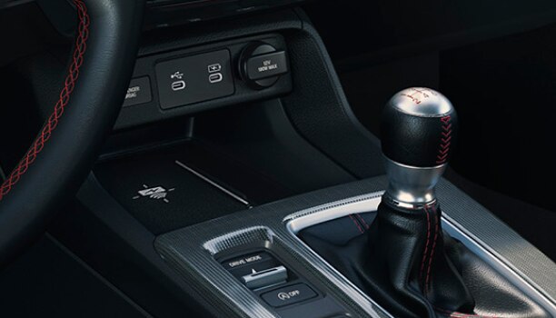 Closeup of wireless charging pad in centre console above the gear shifter. 