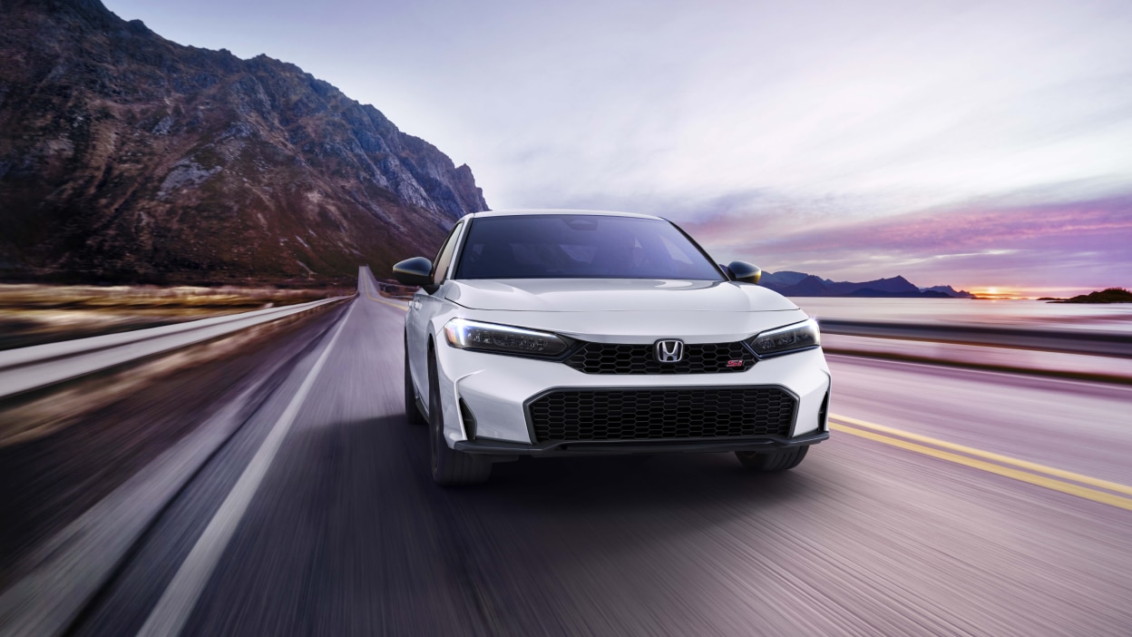 Plan avant d’une Civic Si blanche roulant en direction de la caméra sur une autoroute montagneuse côtière.