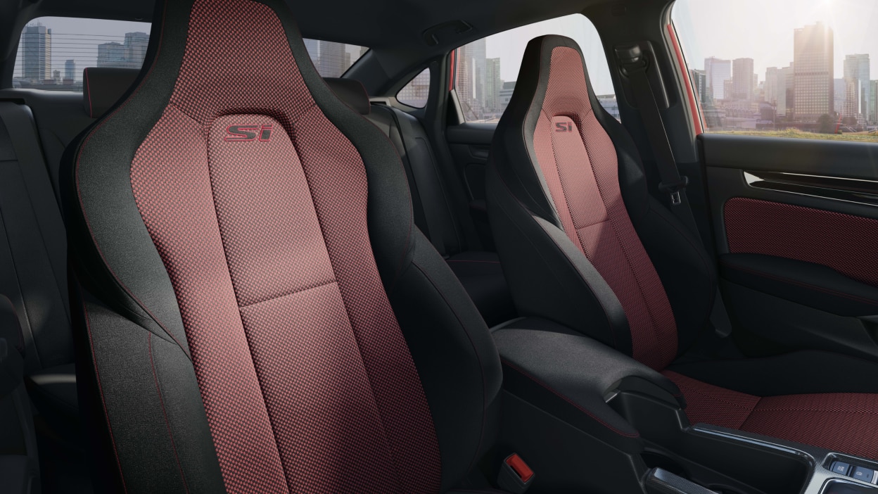 Medium closeup of red and black front row sports seats with “Si” badging.