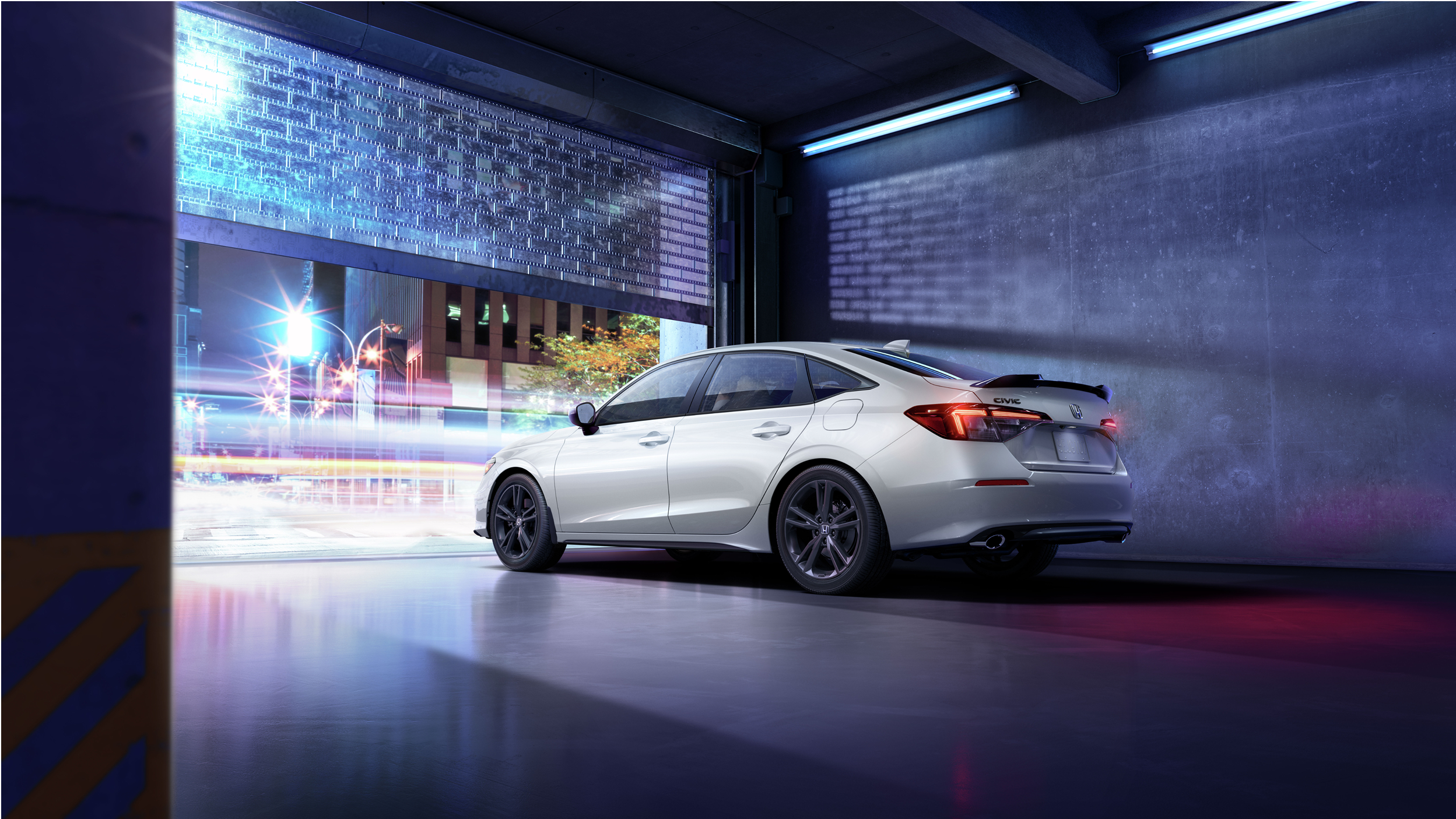 3/4 rear side view of white Civic Si at the garage door, about to pull out of an underground city parkade at night.