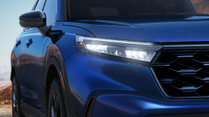 Closeup of front headlight on a blue CR-V. 