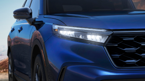 Closeup of front headlight on a blue Honda CR-V. 