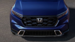 3/4 front bird’s eye view of honeycomb grille on a blue CR-V. 