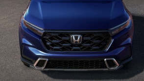 3/4 front bird’s eye view of honeycomb grille on a blue Honda CR-V. 