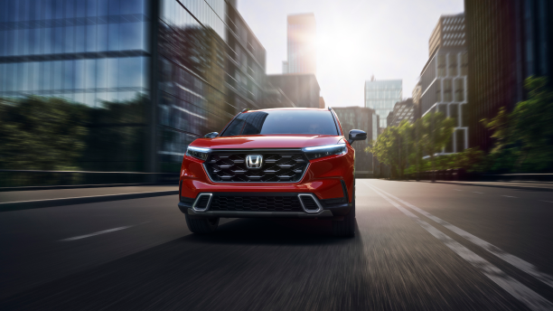 Front view of red CR-V driving in the city; toward camera. 