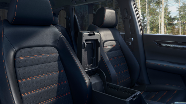 Medium closeup of black front seats with orange stitching.