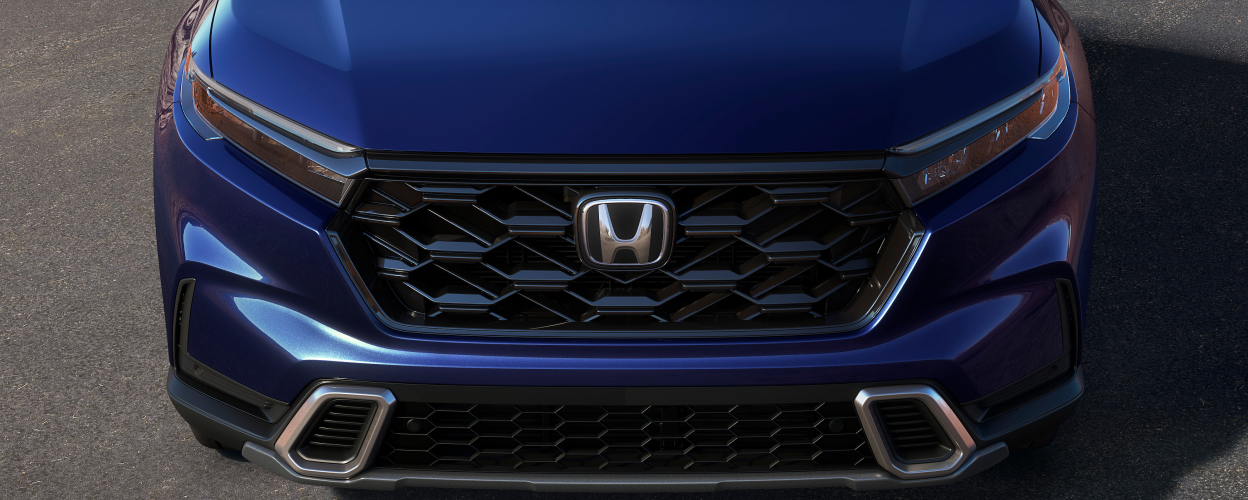 3/4 front bird’s eye view of honeycomb grille on a blue 2023 CR-V.