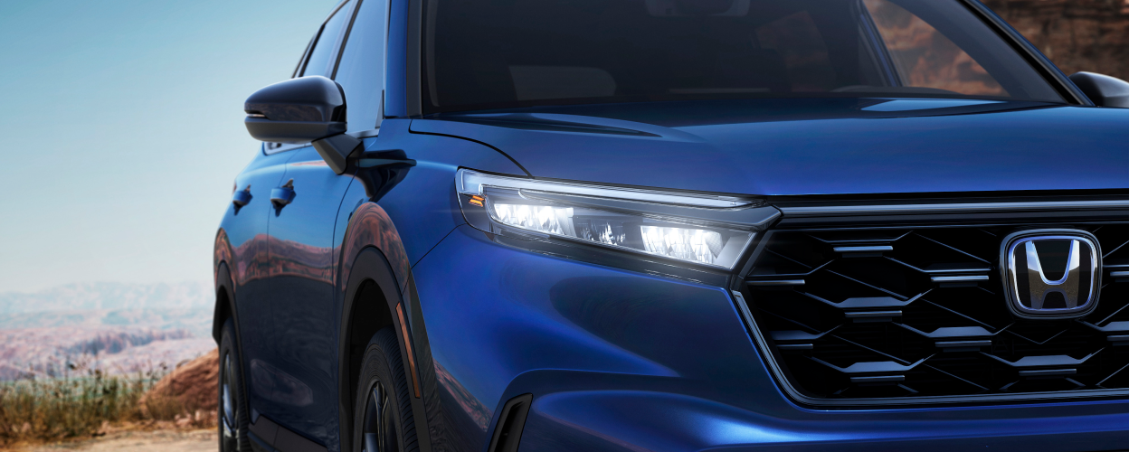 Closeup of front headlight on a blue CR-V.