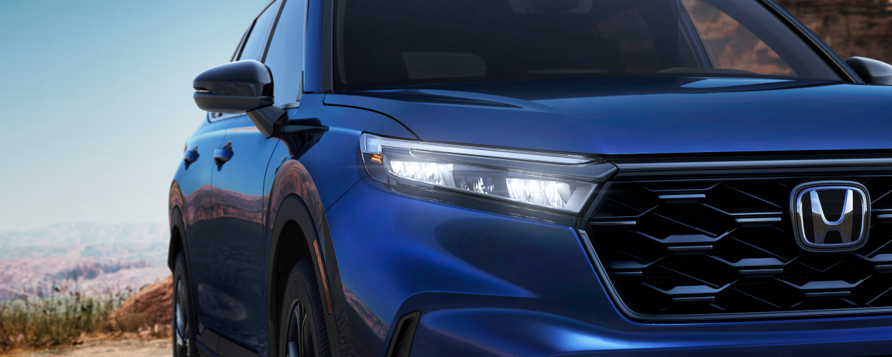 Closeup of front headlight on a blue 2023 CR-V.