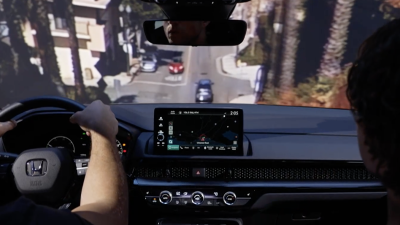 Vue intérieure d’une femme conduisant un CR-V descen-dant une pente en ville.