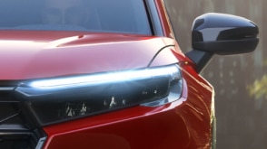 Closeup of front headlight on a red CR-V. 