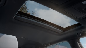 Interior view of open power moonroof letting in sunlight. 	