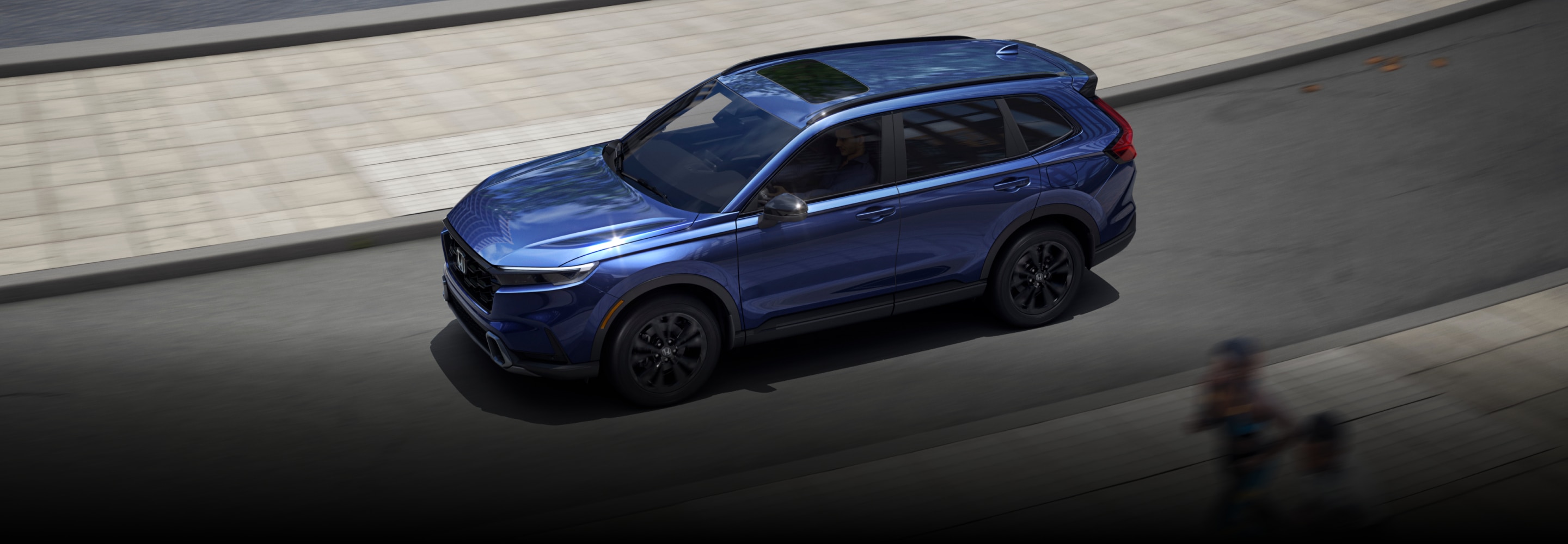 A blue Honda CR-V driving on a city street, seen from above