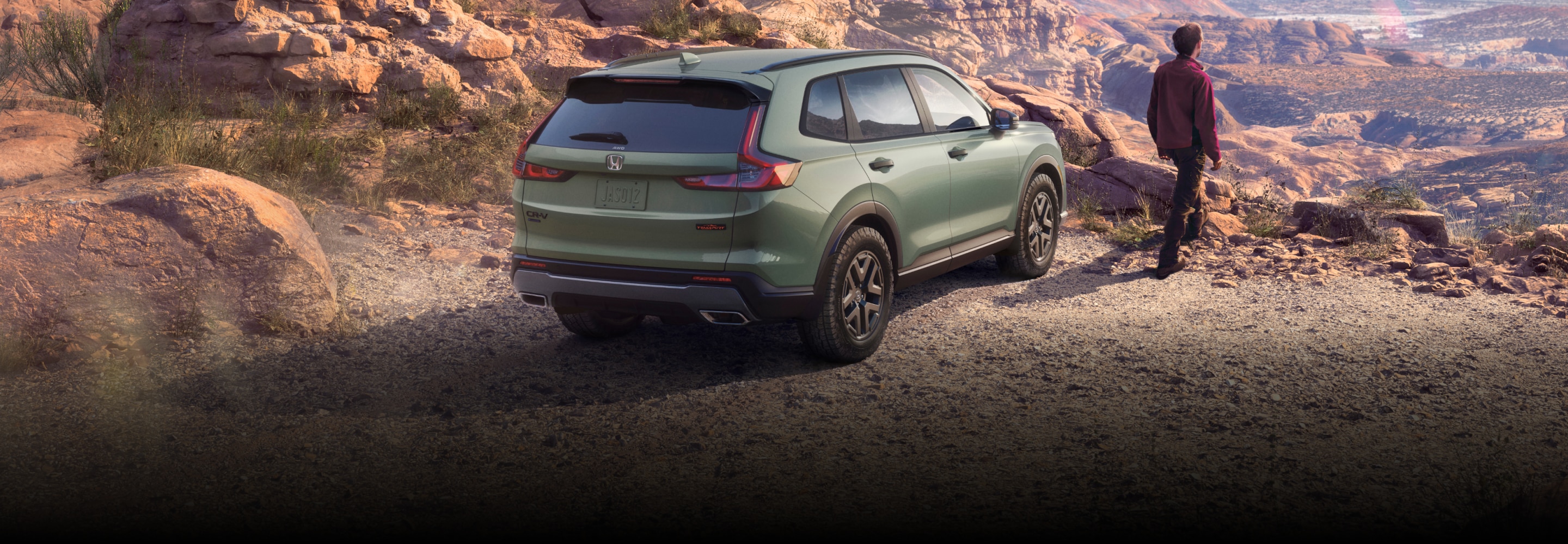 A green Honda CR-V parked at a canyon overlook