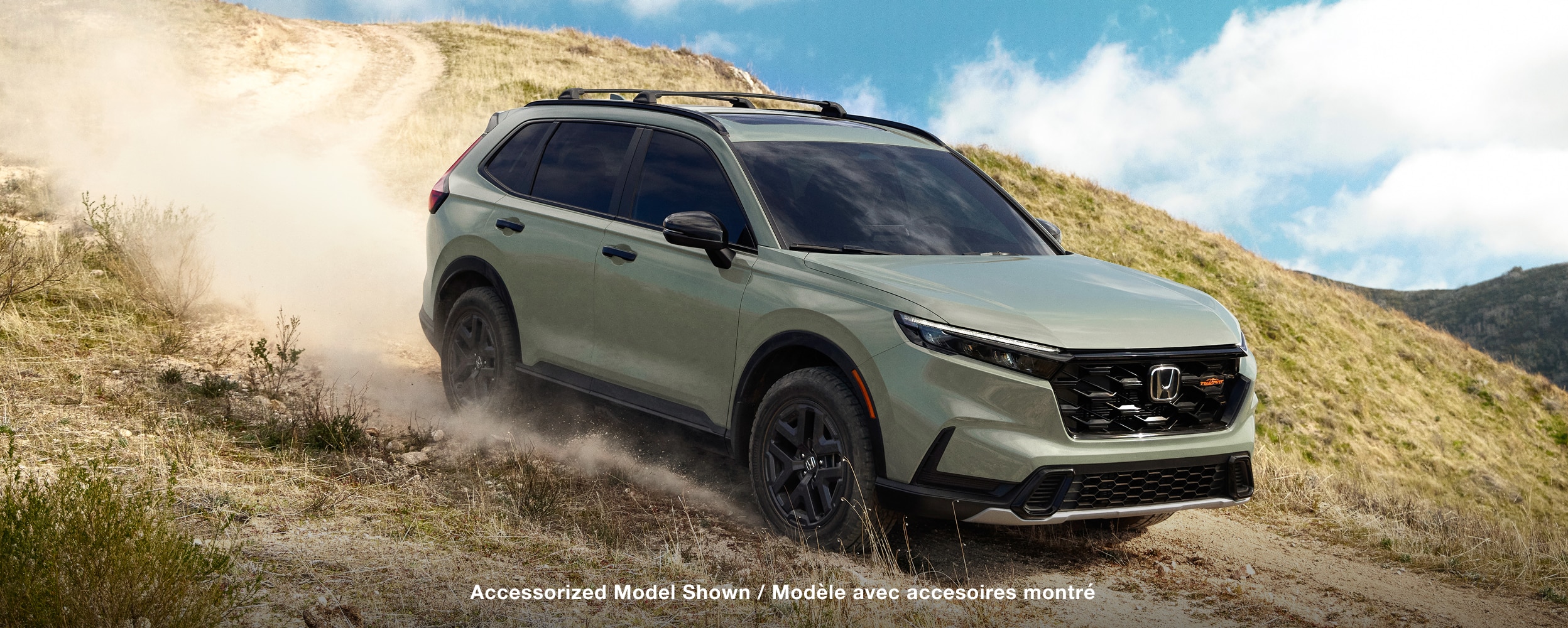 Vue latérale d’un CR-V vert dans un environnement désertique.