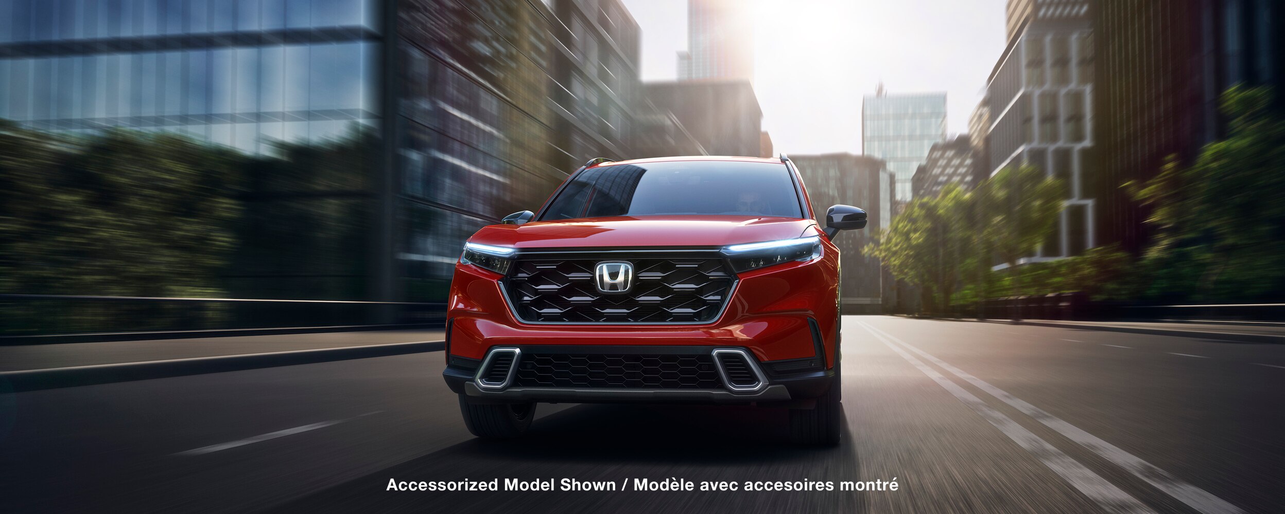 Front view of red CR-V driving on a city street. 