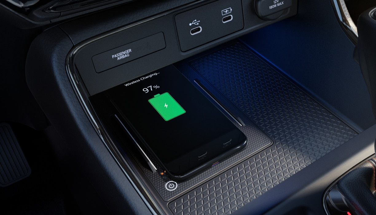 Closeup of a phone charging in the console.