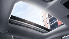 Interior view of open power moonroof letting in sunlight. 