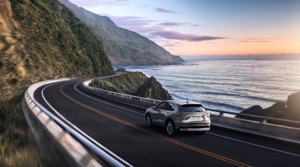 Vue 3/4 d’un HR-V gris roulant le long de la côte. 