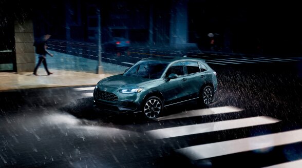 Vue 3/4 arrière d’un HR-V gris roulant la nuit.