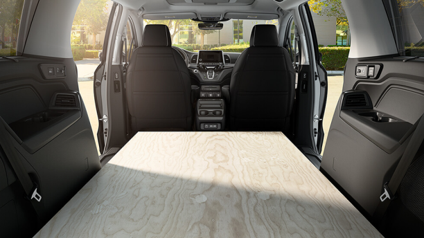 Interior view of Honda Odyssey packed with sheets of plywood.