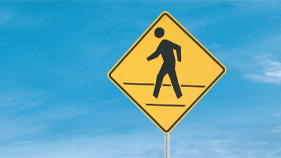 Closeup of “pedestrian crossing” sign.