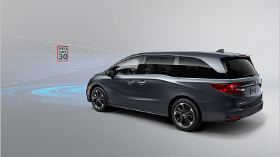 3/4 rear view of Odyssey in front of a speed sign. Blue sensor waves and lines emit from the front.