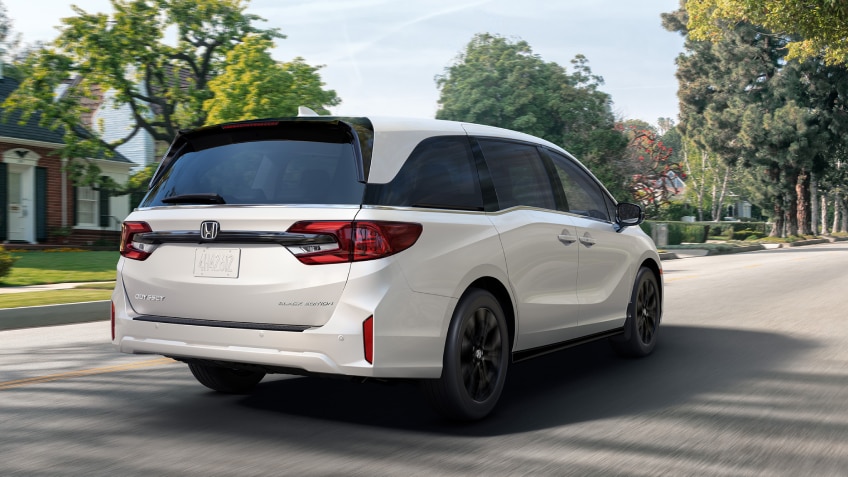 Sideview of white Odyssey, parked lakeside.