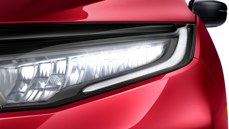Closeup of headlight on red Odyssey on white space.